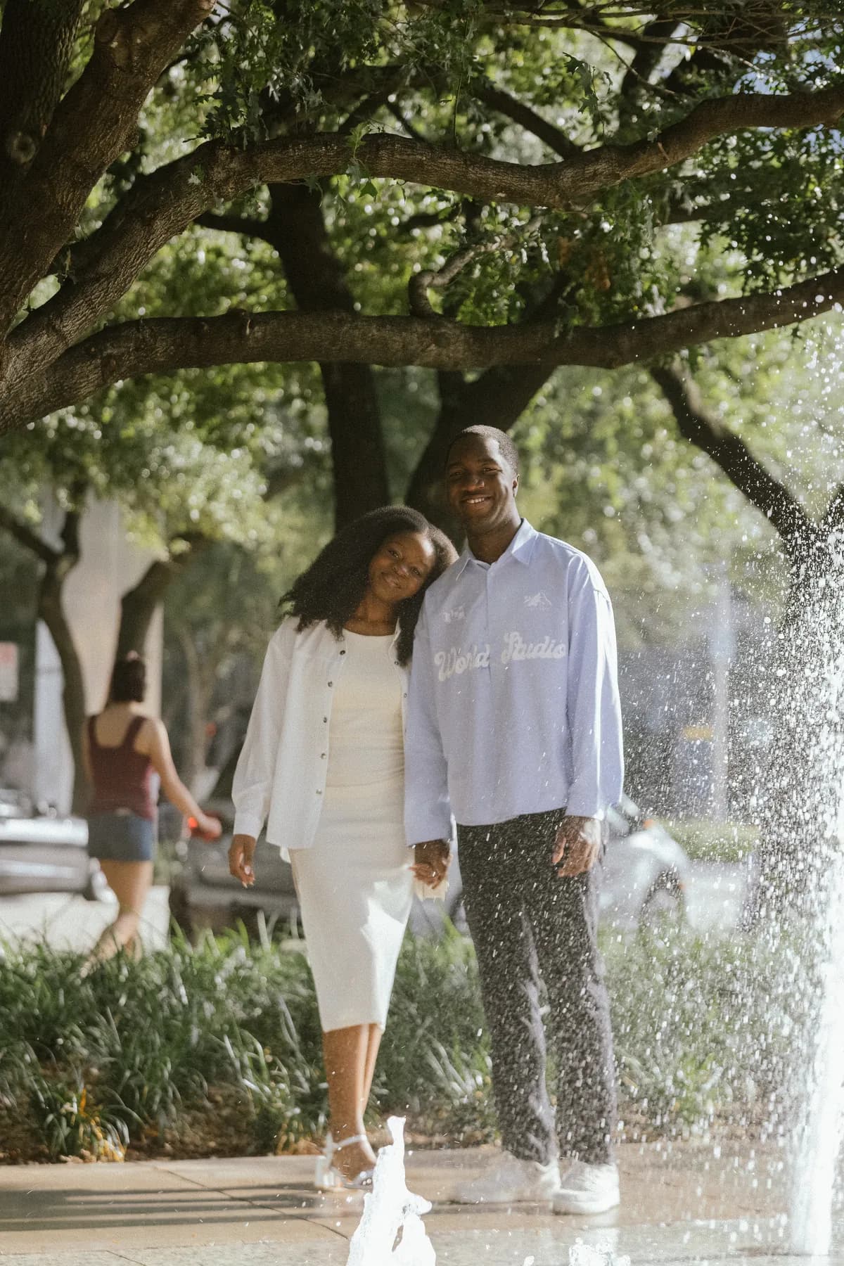 Afriyie leaning on Jeremy’s shoulder beside a fountain