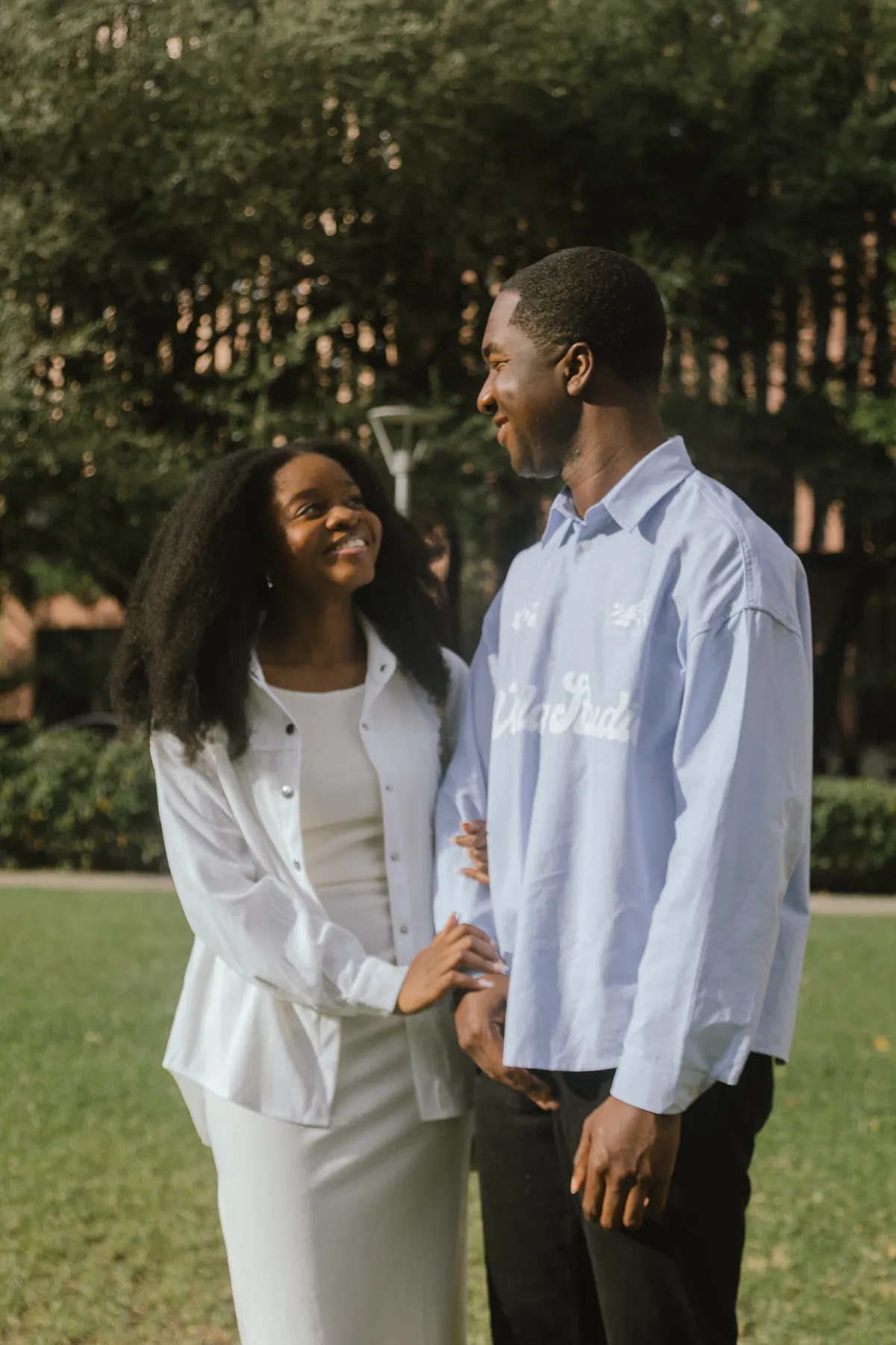 Jeremy and Afriyie standing on a lawn, smiling at each other